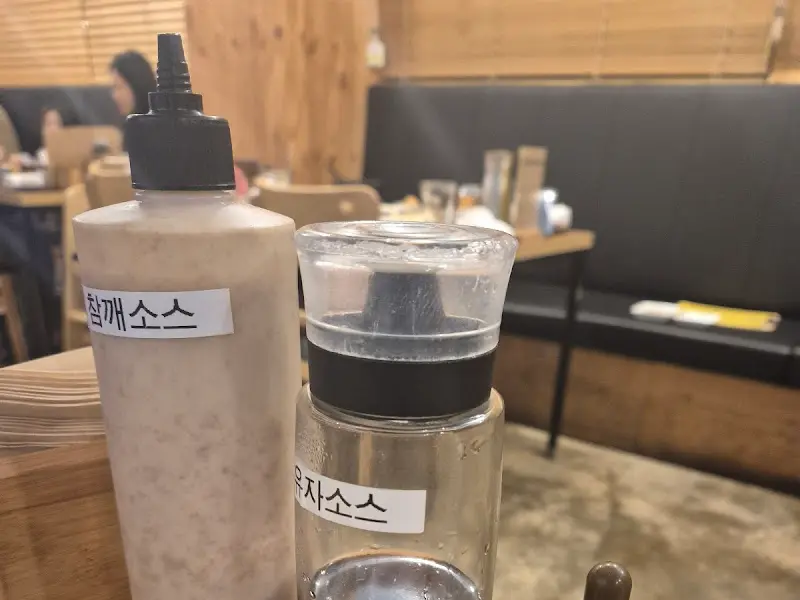 테이블 위에 놓인 참깨 소스와 유자 소스