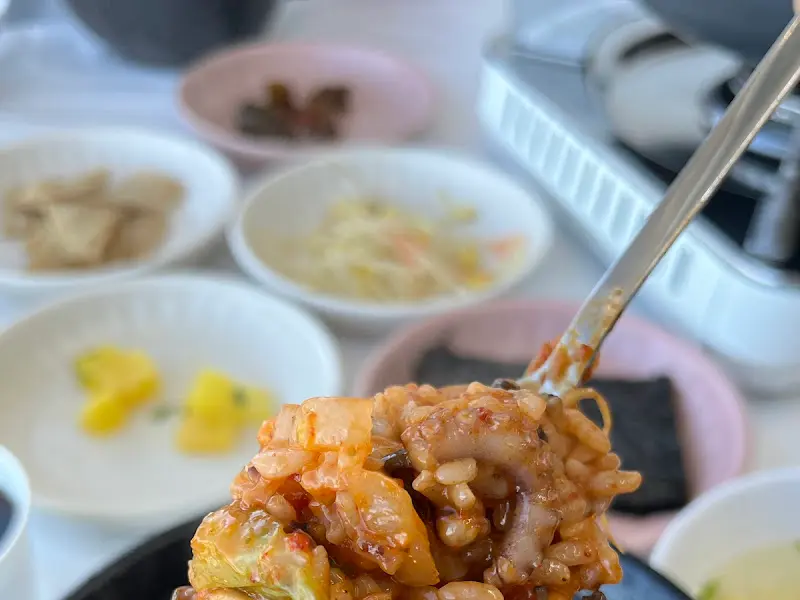 다채로운 밑반찬과 짜글낙지를 밥에 비벼먹는 모습