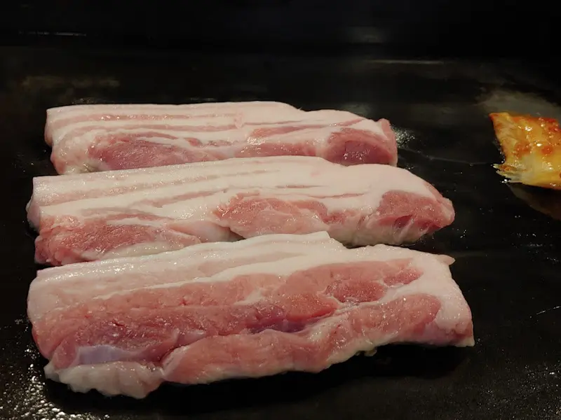 불판 위에서 맛있게 익어가는 약돌돼지 삼겹살