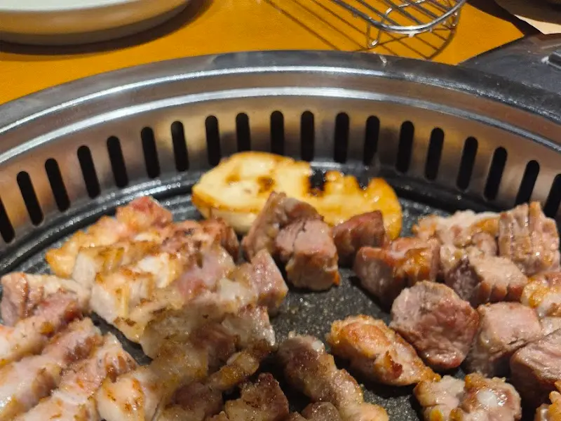 숯불 위에서 노릇하게 익어가는 돼지고기