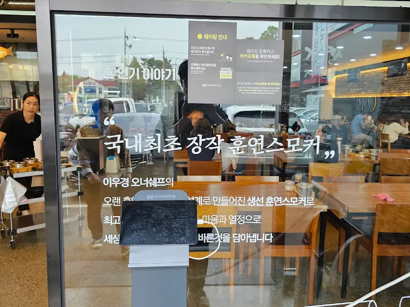 경성 식당 외부 유리창에 적힌 '국내 최초 장작 훈연 스모커' 문구