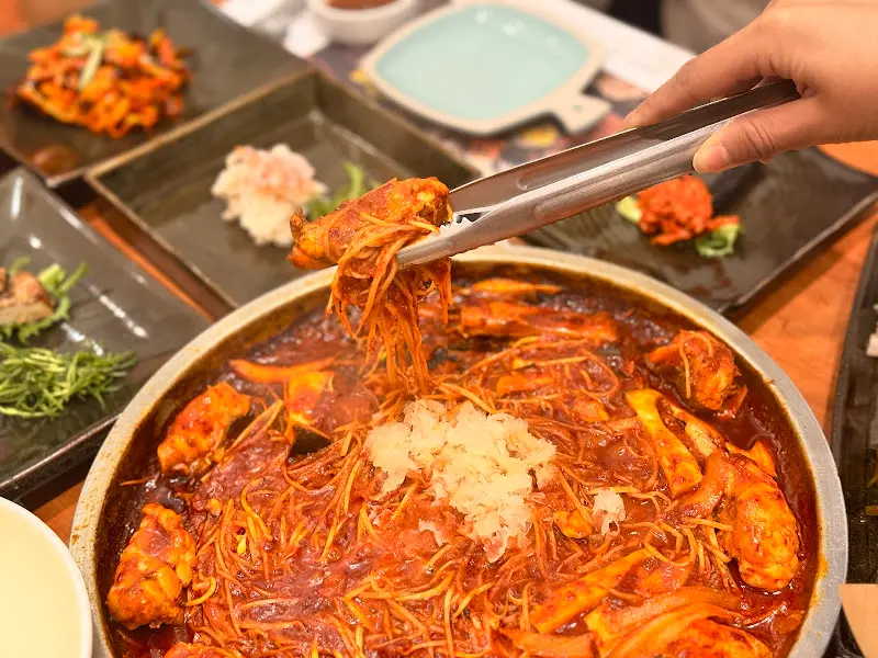 복어 불고기를 집게로 들어올리는 모습