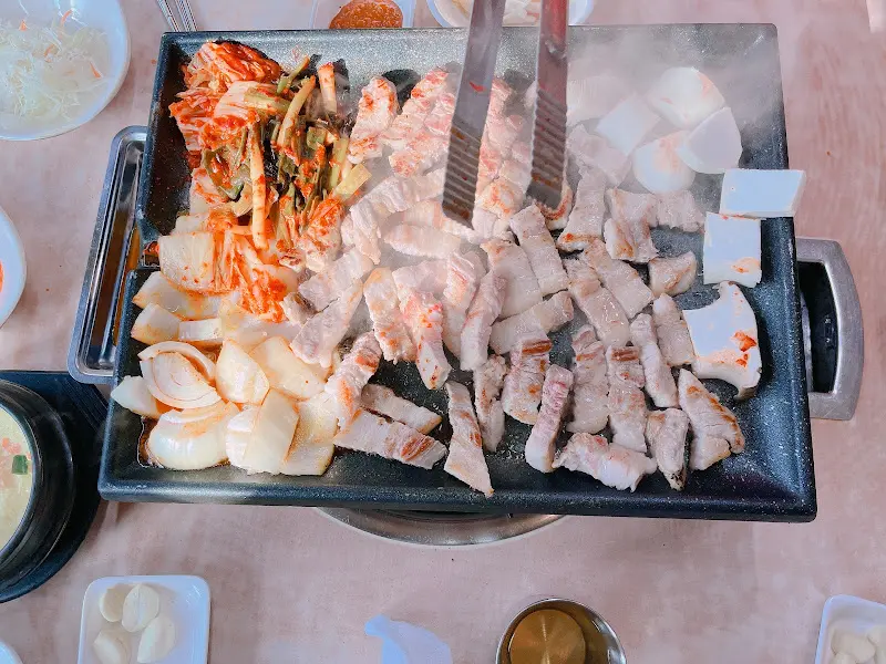 불판 위에서 익어가는 삼겹살과 김치