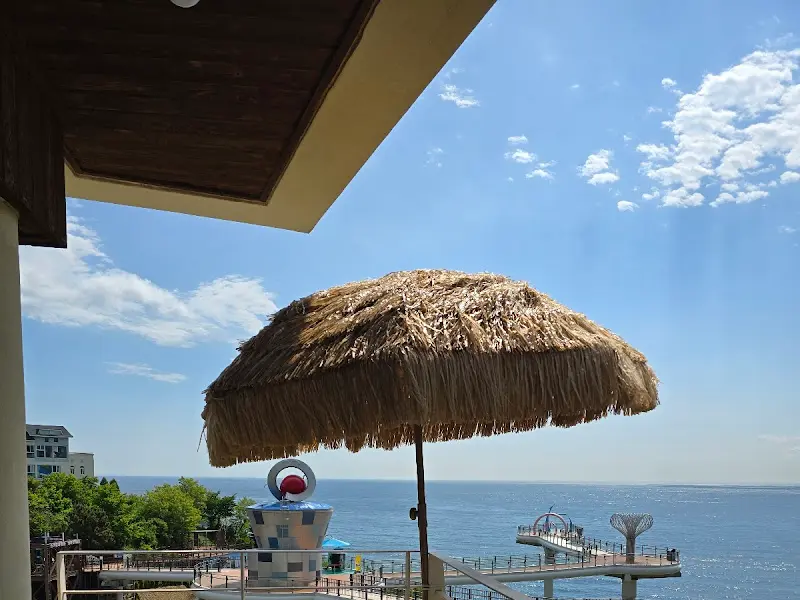 짚 파라솔 아래에서 햇살을 즐기는 모습