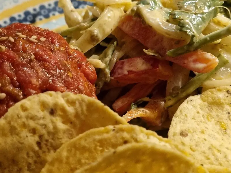 붉은 빛깔의 육회와 나초의 조화