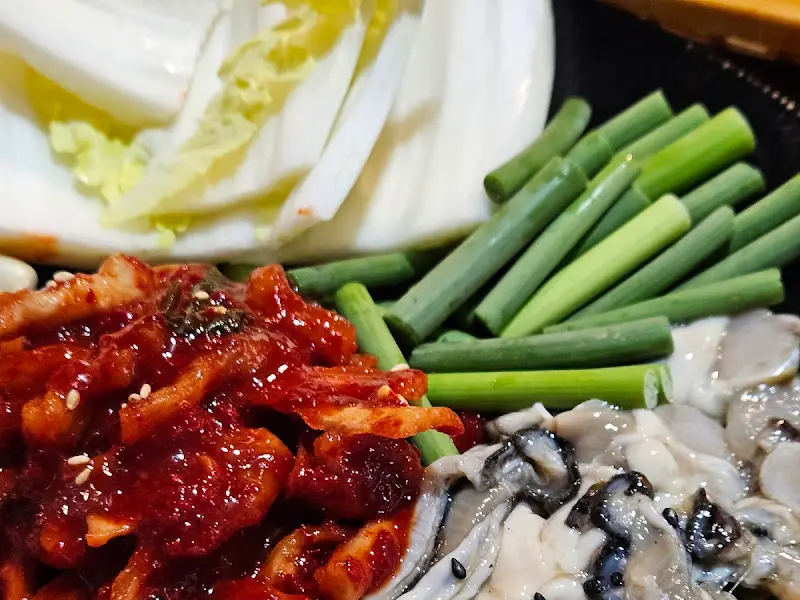 신선한 굴과 수육, 김치가 담긴 굴보쌈 한상차림