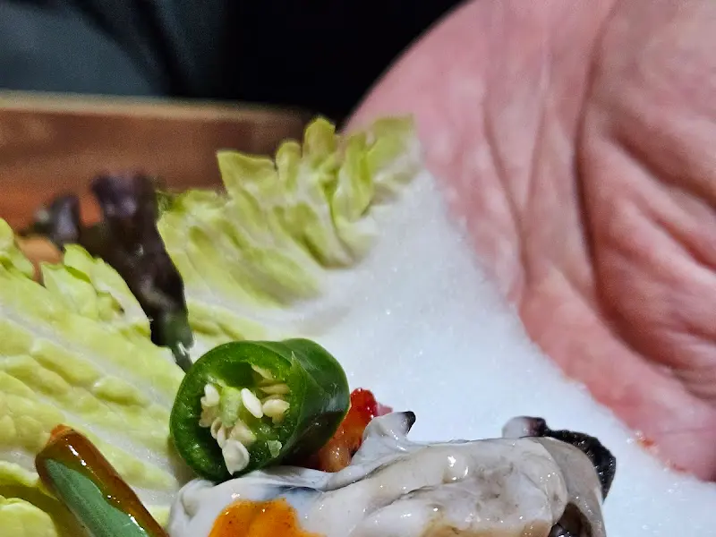 굴보쌈을 싸 먹는 모습