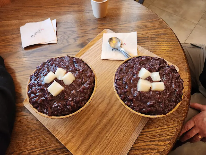 나무 쟁반 위에 놓인 팥빙수와 단팥빵, 그리고 냅킨