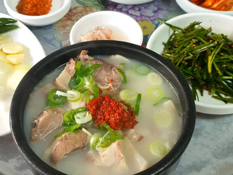 다진 양념이 풀어져 붉은 빛을 띠는 돼지국밥