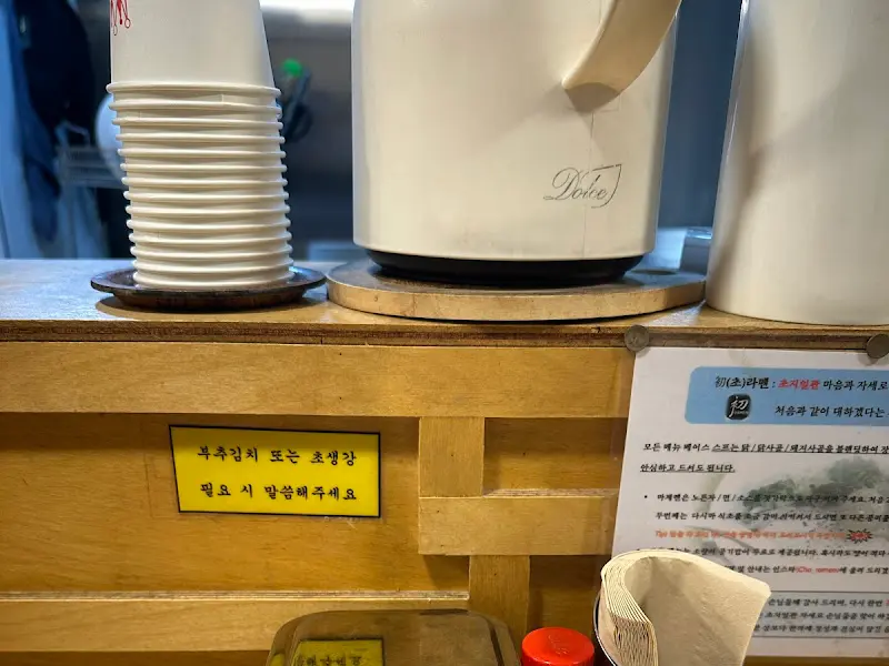 따뜻한 물통과 컵이 놓인 테이블