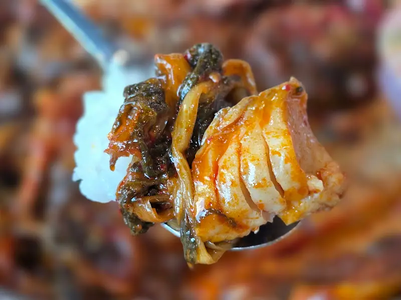 밥 위에 코다리조림과 시래기를 얹어 한 입