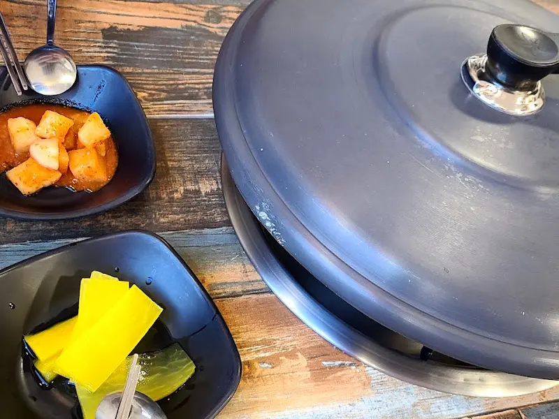 깔끔하게 정돈된 테이블과 닭갈비를 덮은 냄비 뚜껑