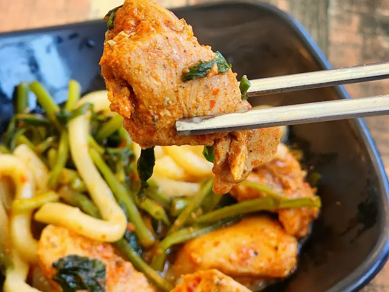 젓가락으로 집어 올린 닭갈비 한 점