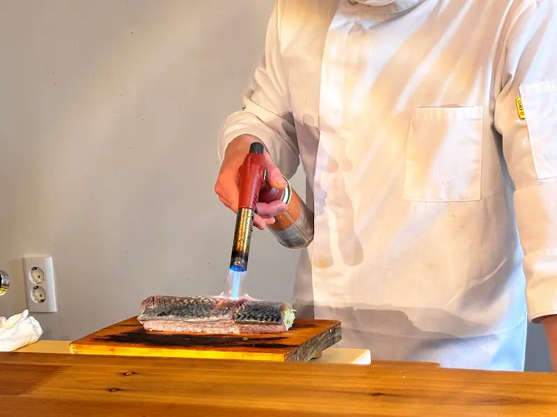 셰프가 토치로 고등어 봉초밥을 굽는 모습