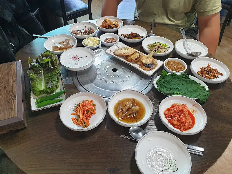 테이블 가득 차려진 반찬들과 쌈 채소