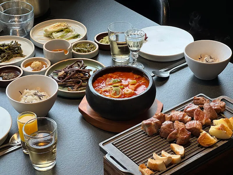 흑돼지 구이와 김치찌개, 톳 솥밥이 차려진 테이블