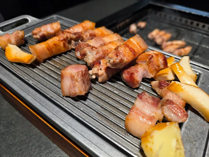 잘 구워진 흑돼지 오겹살과 멜젓