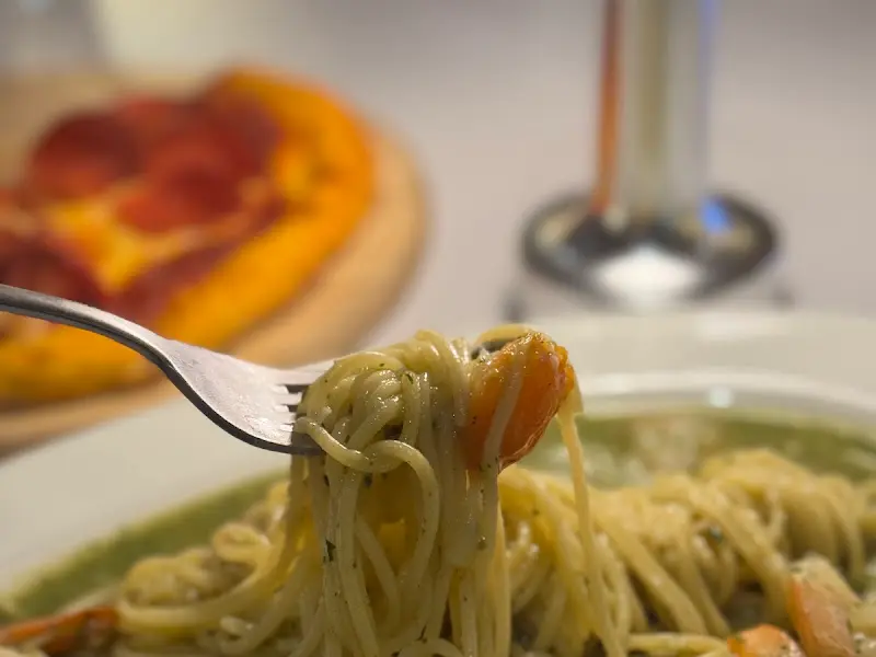 포크에 감겨 올려진 쉬림프 바질 오일 파스타