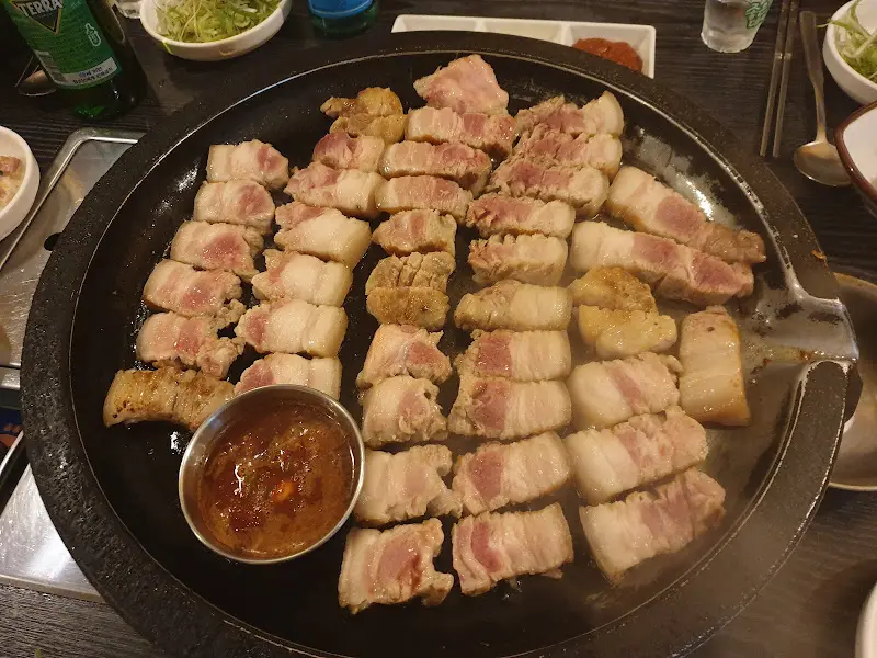 불판 위에 가지런히 놓인 돼지고기