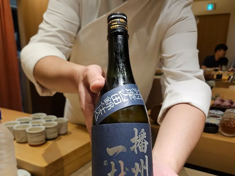 셰프가 사케를 보여주는 모습