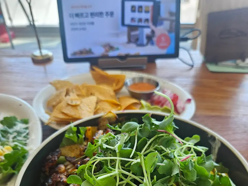 나쵸와 소스, 그리고 신선한 샐러드가 함께 제공되는 모습