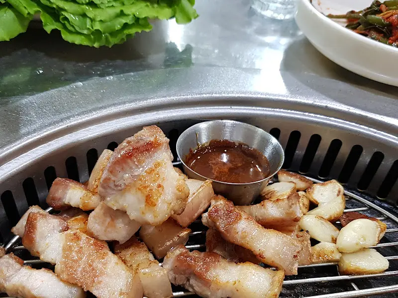 잘 구워진 흑돼지 삼겹살과 마늘, 멜젓의 조화