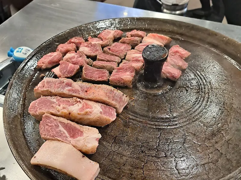 솥뚜껑 위에 올려진 삼겹살과 목살