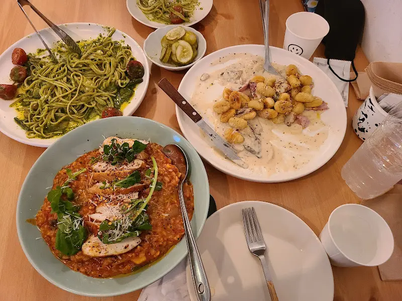 테이블 위에 놓인 명란 버터 파스타, 스파이시 베이컨 리조또, 그린 파스타