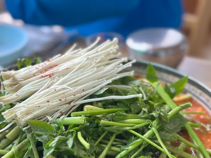 쑥갓과 팽이버섯이 듬뿍 올려진 메기매운탕