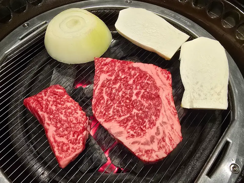 숯불 위에 올려진 한우와 버섯, 양파