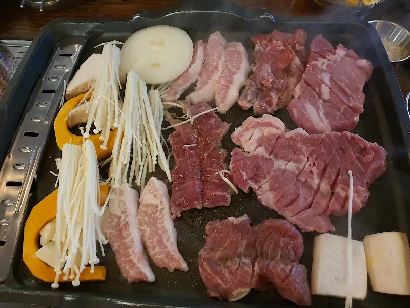 불판 위의 삼겹살과 채소