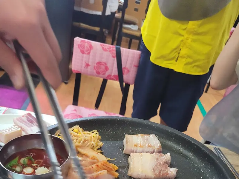 직원이 오겹살을 구워주는 모습