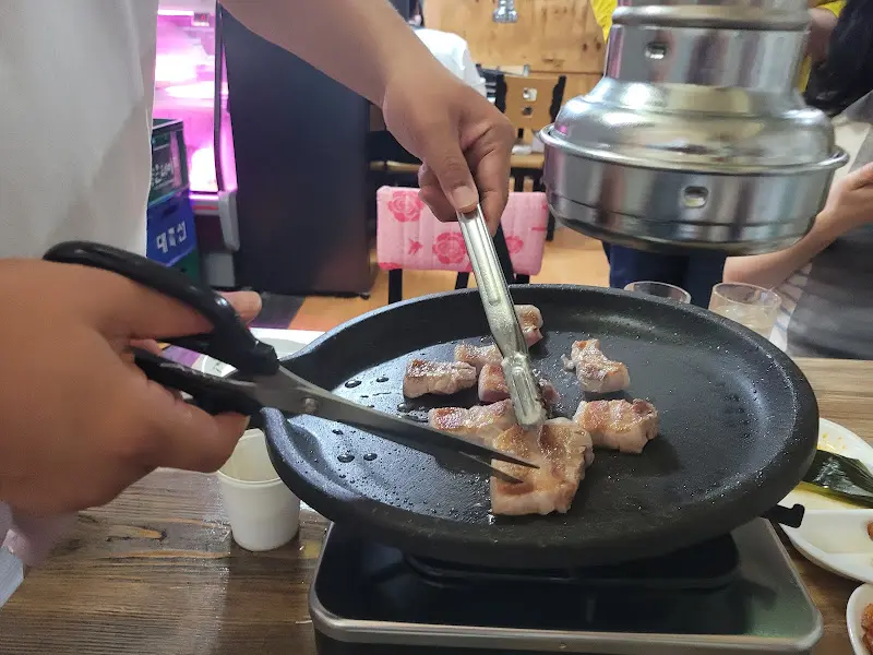 가위로 오겹살을 자르는 모습