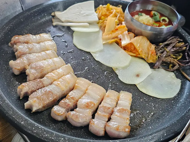 잘 구워진 오겹살과 гарнир крупным планом