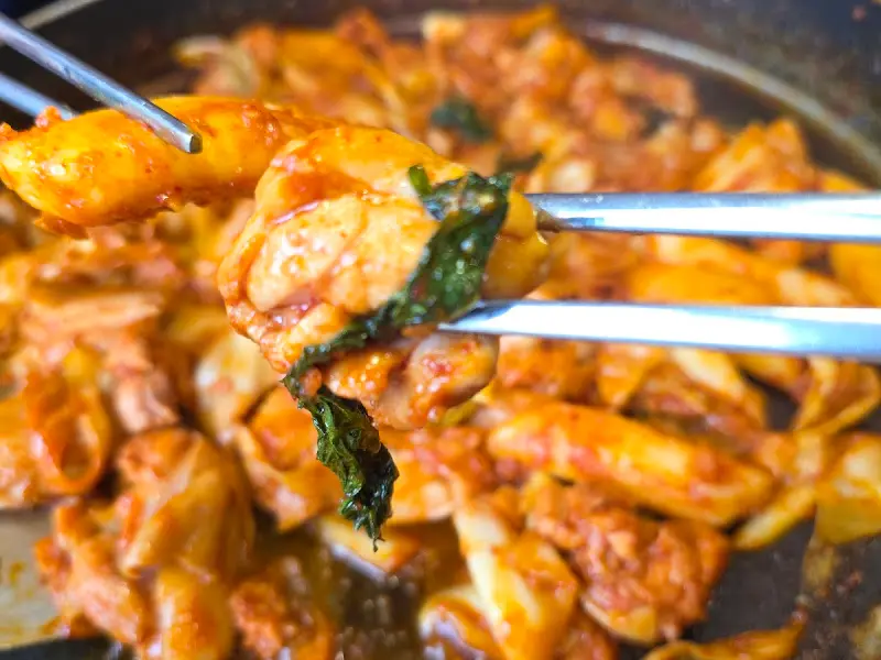 젓가락으로 집어 올린 닭갈비 한 점