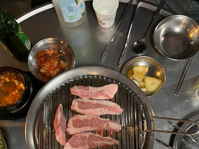 테이블에 놓인 밑반찬과 숯불