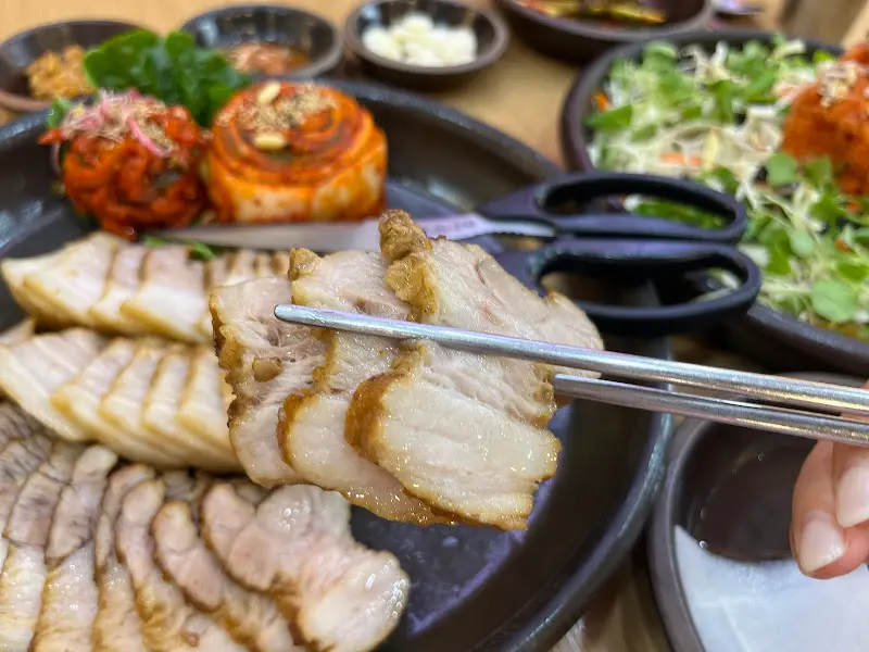 젓가락으로 집어 올린 윤기 흐르는 보쌈