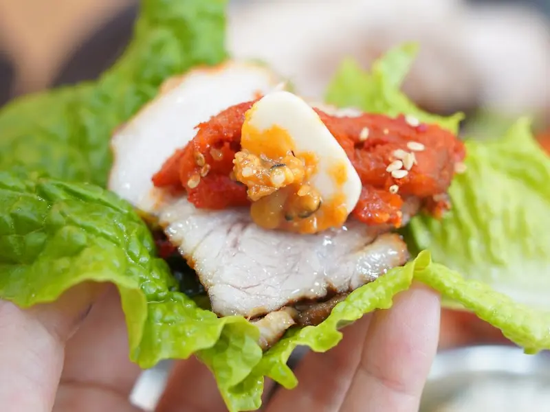 상추에 보쌈, 김치, 마늘을 얹어 한 쌈