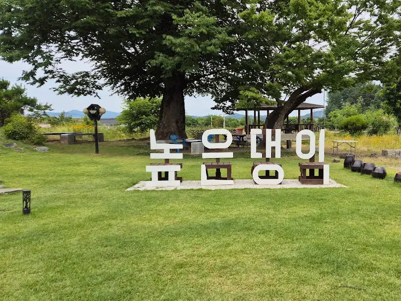 높은댕이 카페의 넓은 잔디밭과 '높은댕이' 글자가 놓여있는 모습