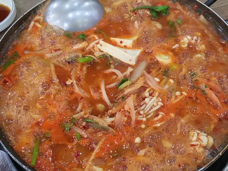 부대찌개를 국자로 뜨는 모습