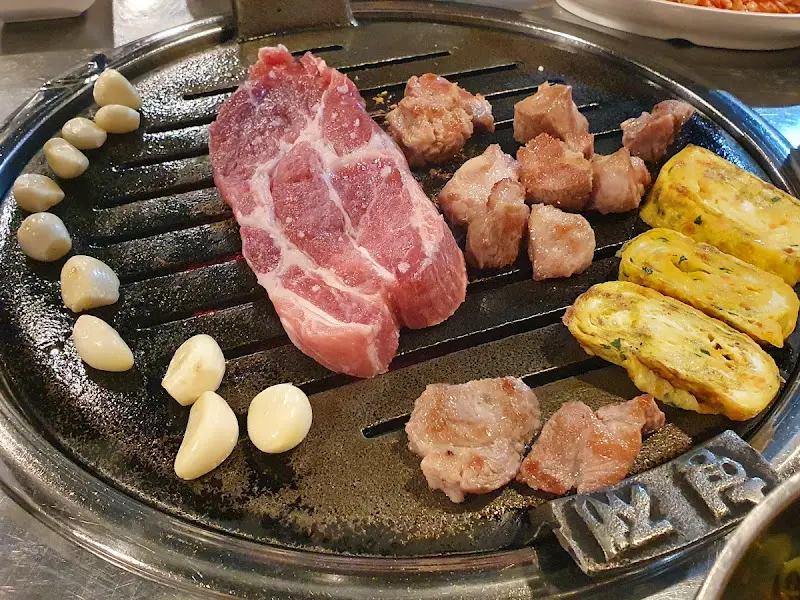 불판 위에 구워지는 목살과 마늘