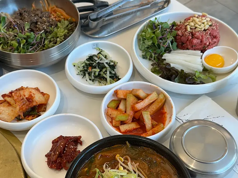 다채로운 밑반찬과 한우 육회 비빔밥