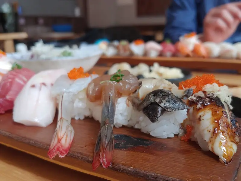 나무 도마 위에 다양한 종류의 초밥이 놓여 있는 모습