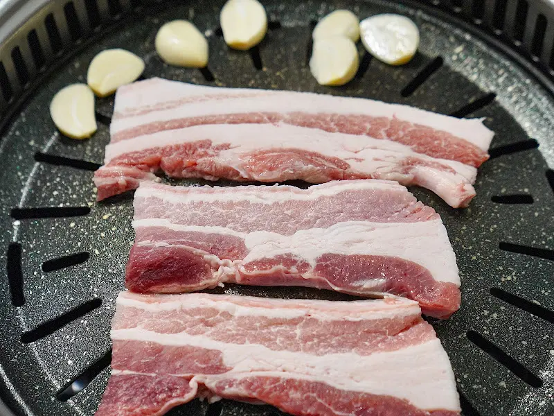 불판 위에 올려진 약돌돼지 삼겹살