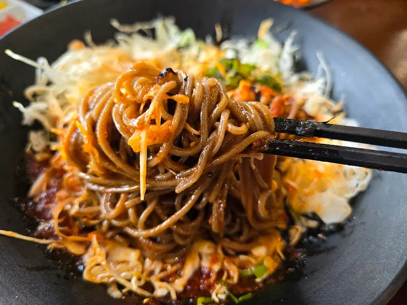 비빔소바를 젓가락으로 들어 올리는 모습