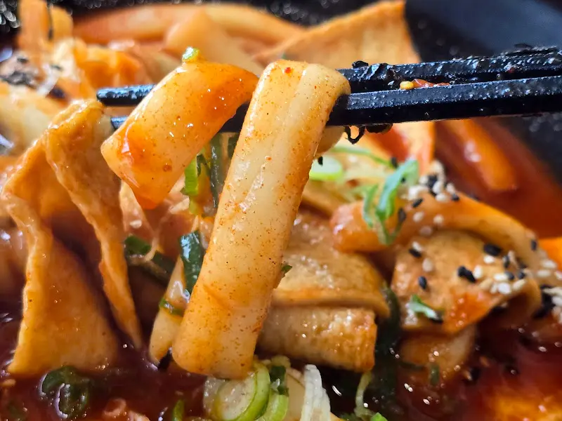 떡볶이 떡을 젓가락으로 집어 올리는 모습