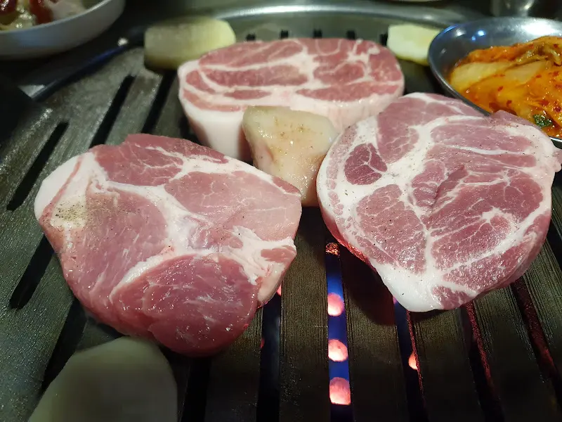 연탄불 위에서 노릇하게 익어가는 두툼한 목살