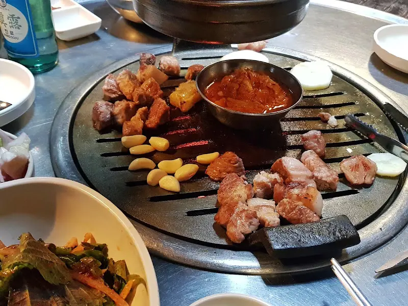 연탄불 위에서 익어가는 갈매기살과 김치