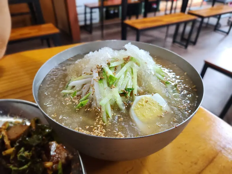 놋그릇에 담겨 나온 물냉면과 기본 반찬