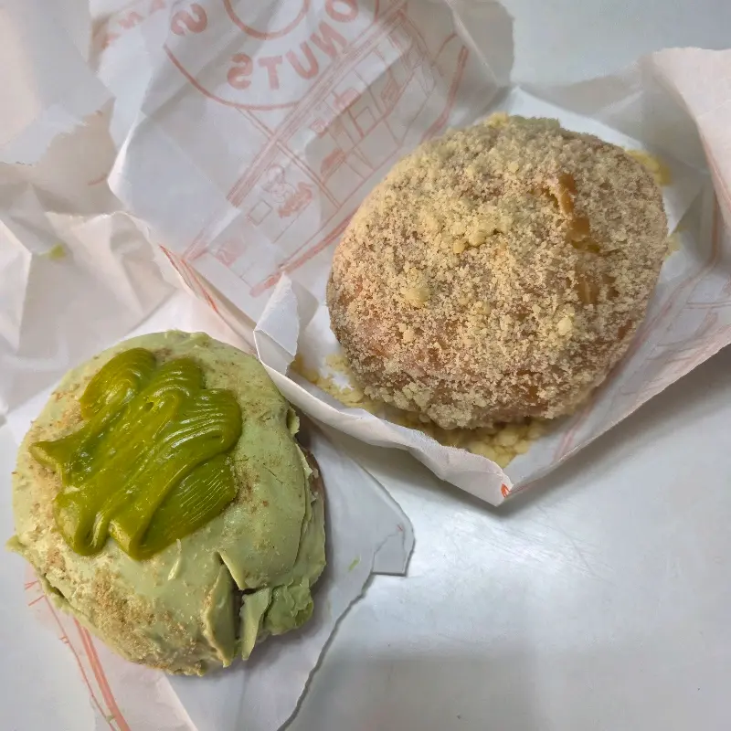 피스타치오 도넛과 튀김가루 같은 토핑이 올려진 도넛